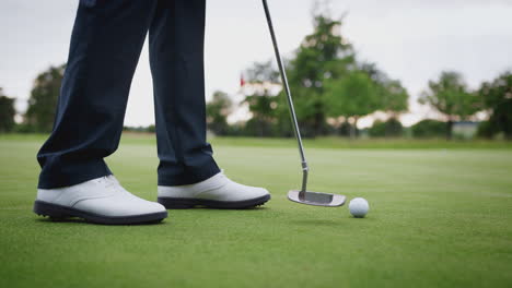 close-up de uma jogadora de golfe colocando a bola no verde