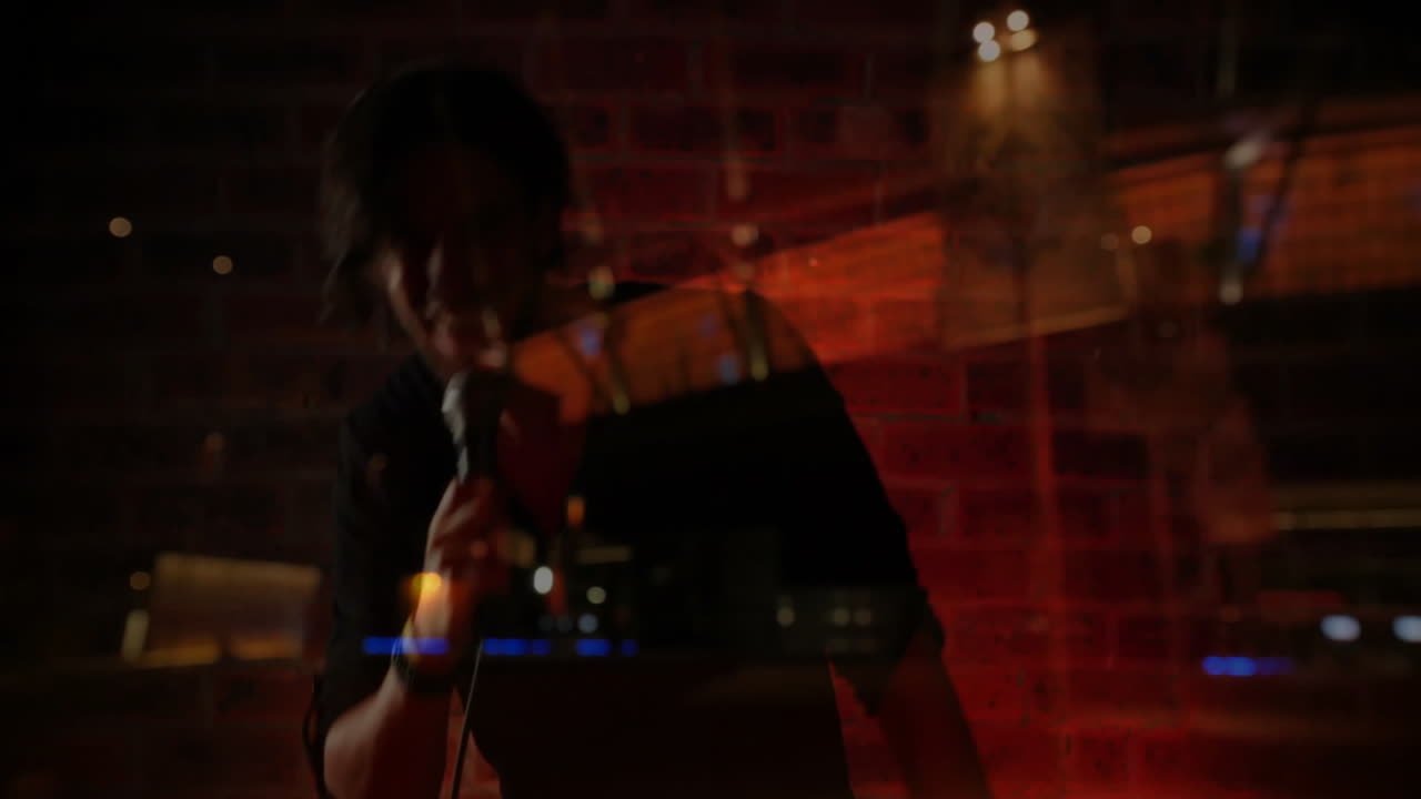 Male singer leaning forward on stage, projecting animated music waveform bars over brick backdrop