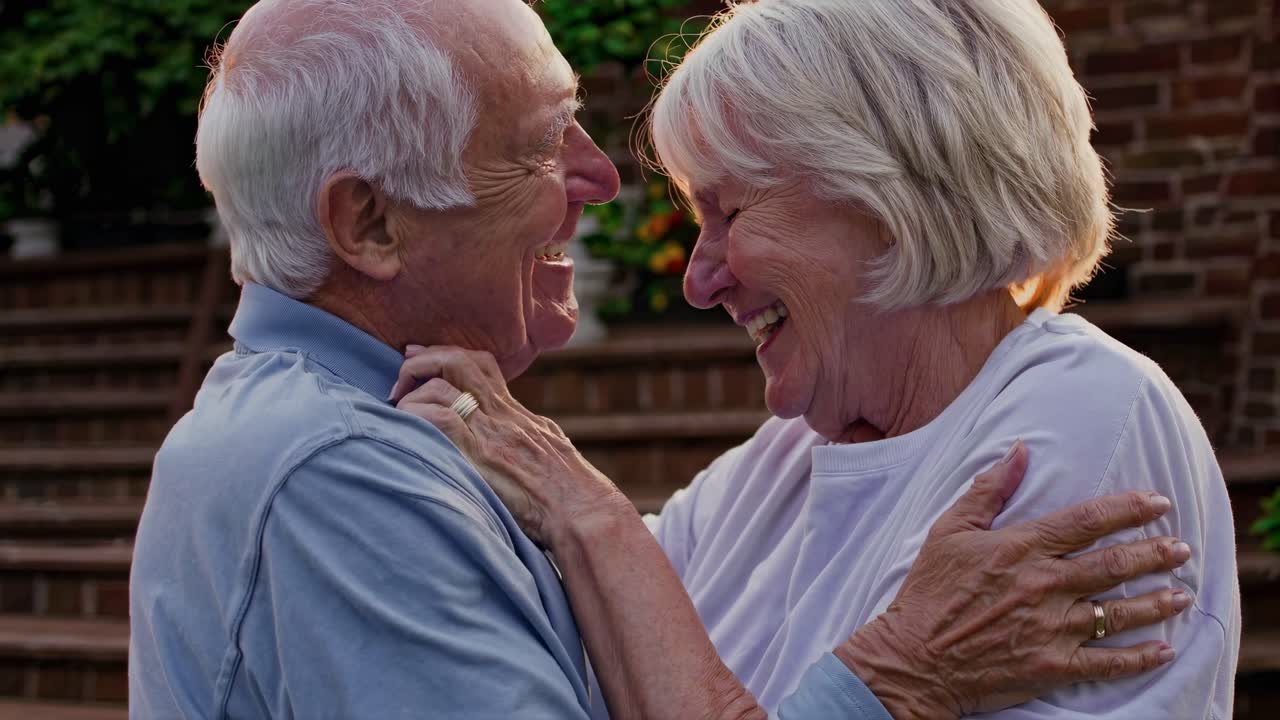 A heartwarming video scene of an elderly couple laughing and embracing