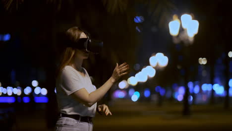 young girl simulated virtual reality work in glasses in modern big city at night on my lanterns and beautiful bokeh of passing cars and buildings