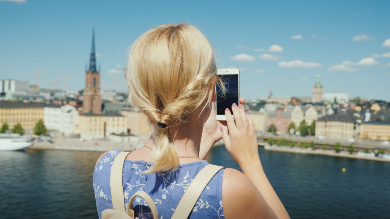 한 여성이 스웨덴 스톡홀름 시의 아름다운 전망을 촬영하고 있습니다.