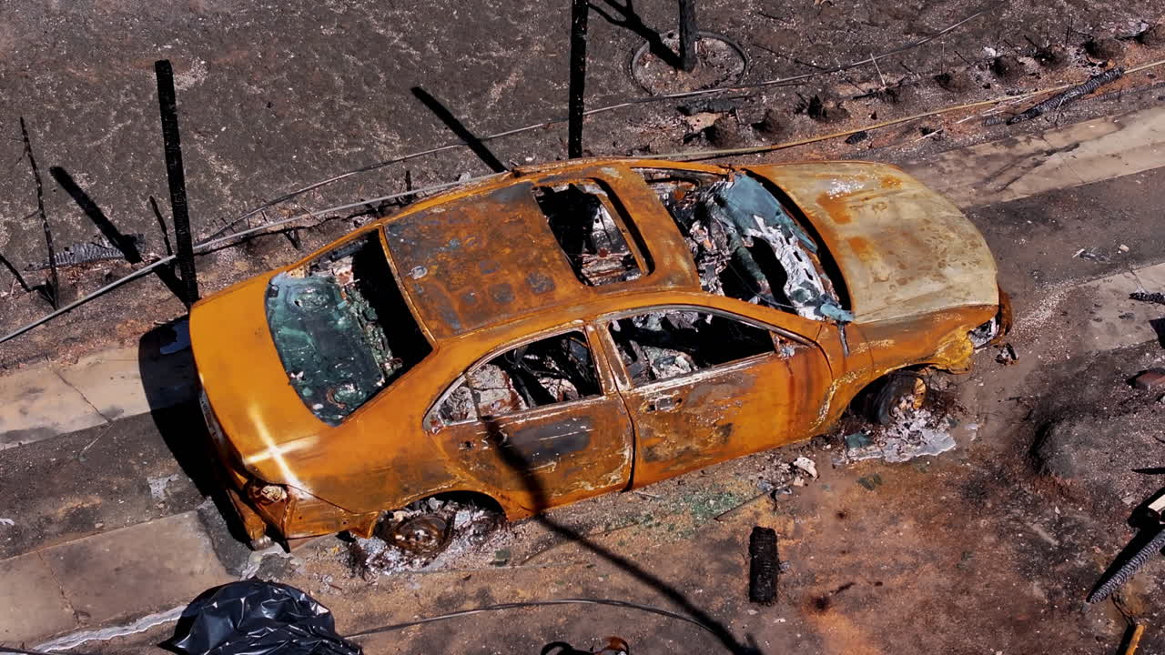 Burnt-out car in a devastated area