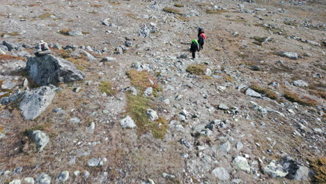 topview of three people hiking, climbing a trail summit mountain footpath, rocky deserted high altitude landscape