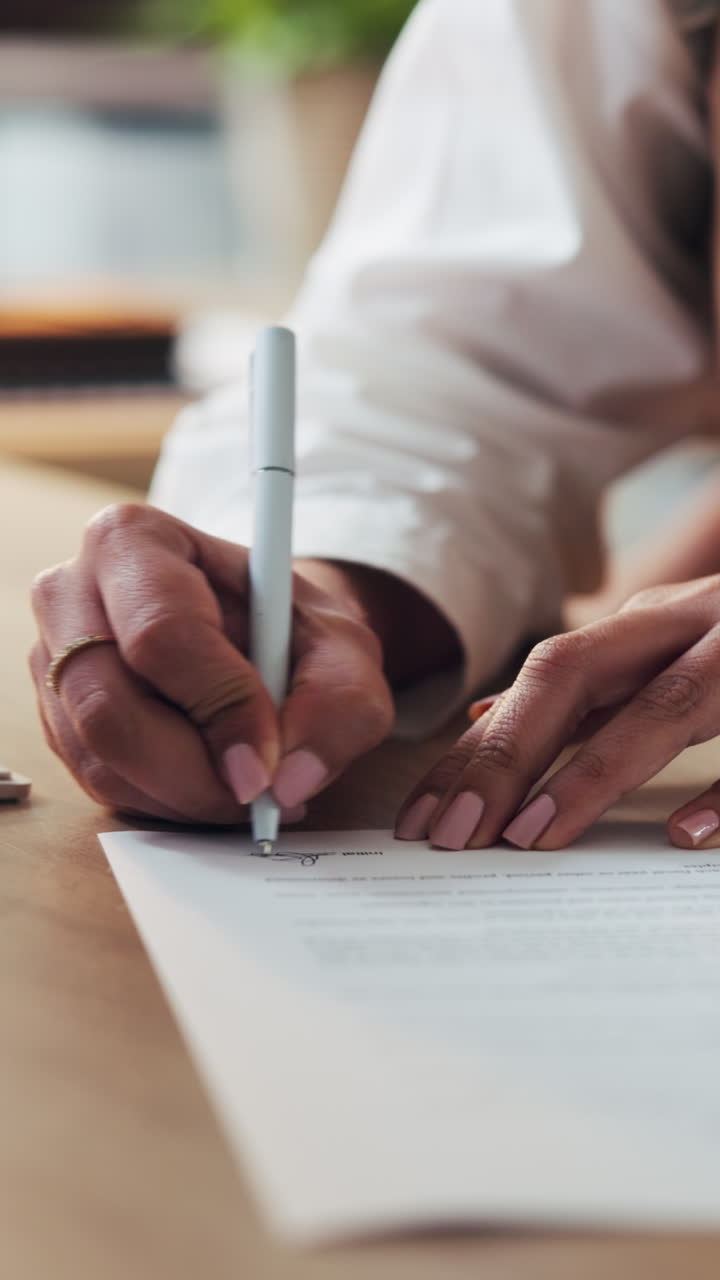 Close-up of a Person's Hand Signing a Business Document with a Pen