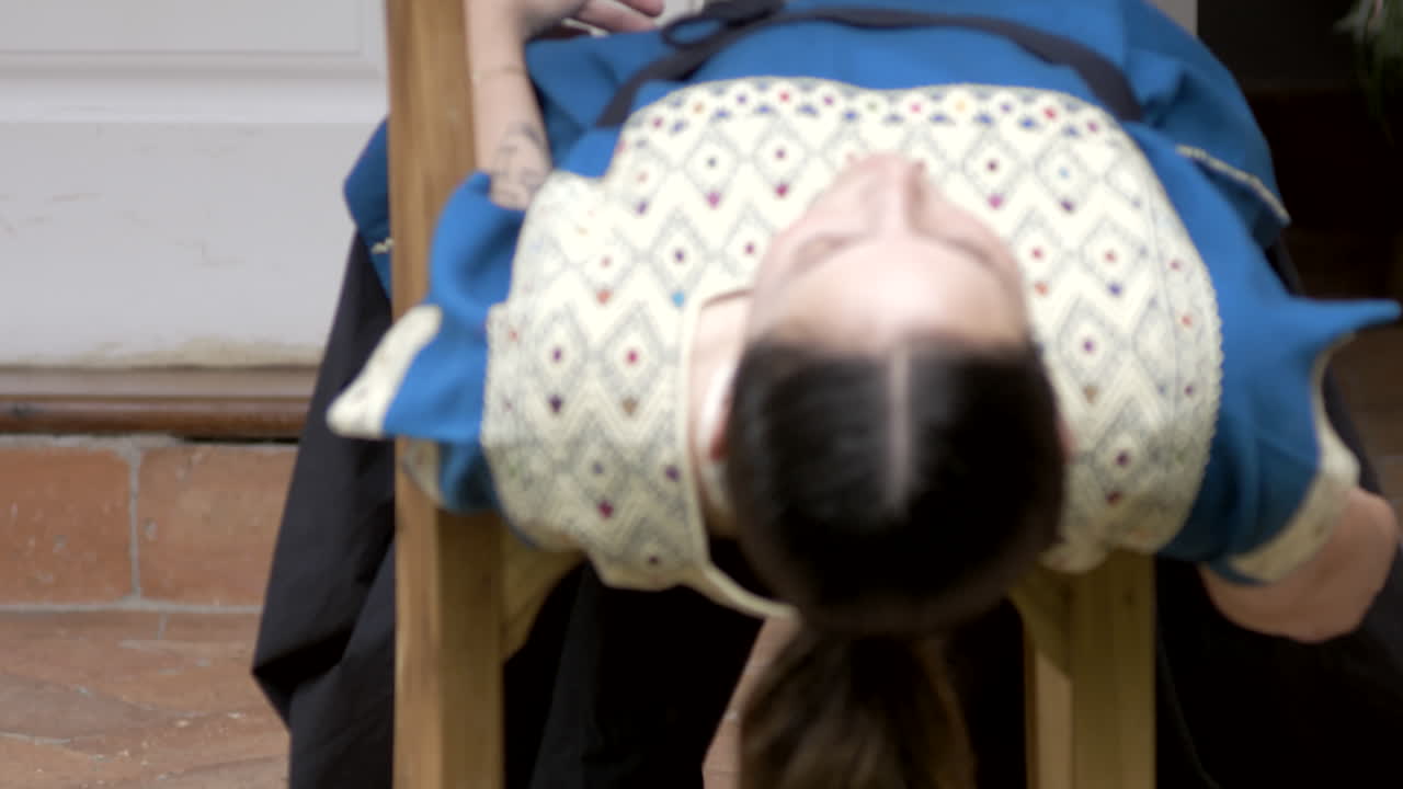 안데스의 전형적인 드레스, 예술적인 춤 예술과 함께 집 정원에 있는 의자 사이에서 춤을 추는 아름다운 소녀