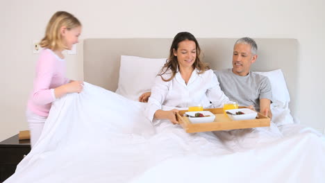 girl bringing the breakfast to her parents