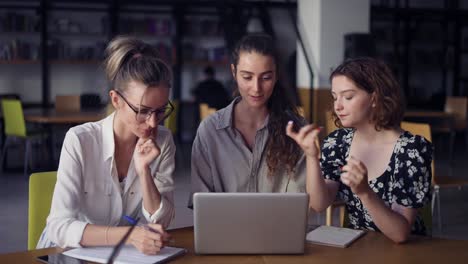 Fröhliche-Frauen-Unterhalten-Sich,-Während-Sie-Auf-Den-Laptop-Schauen