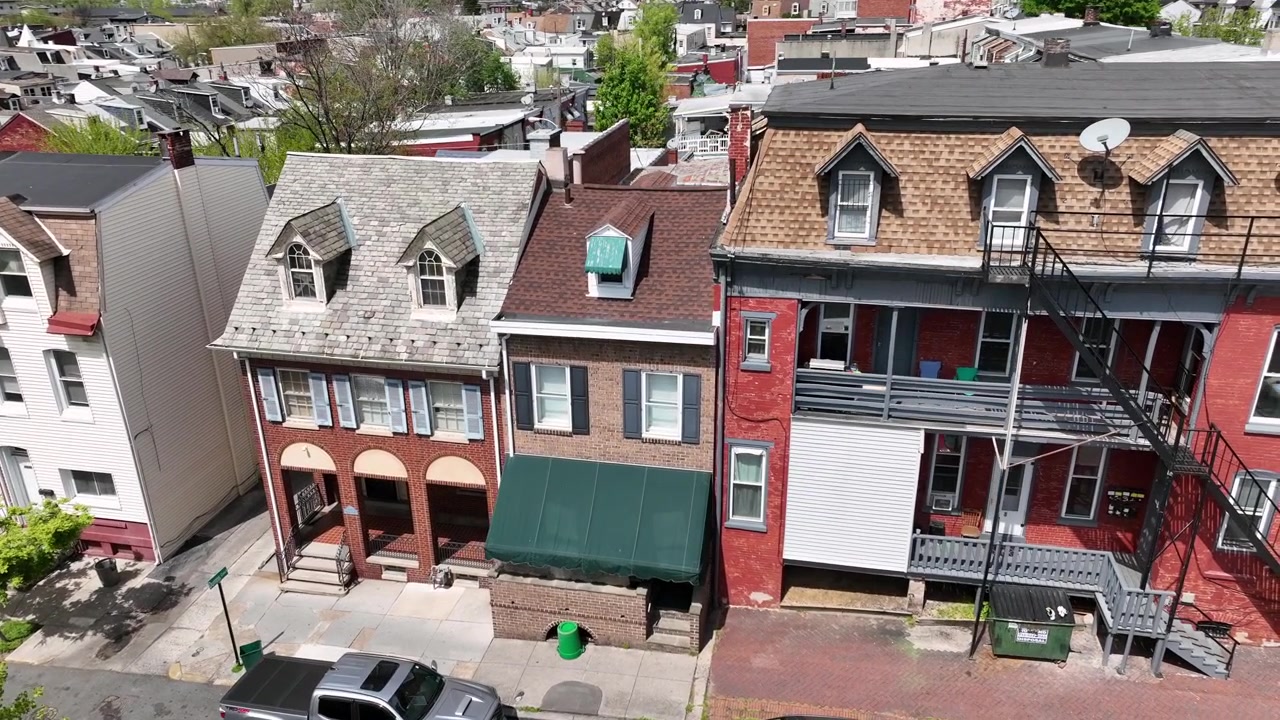 Amerikansk bykvarter. Forstadsgader med rækkehuse og parkerede biler. Tæt beboelsesområde, luftfoto. Drone-orbitoptagelse. Amerikanske huse og bygninger om sommeren.