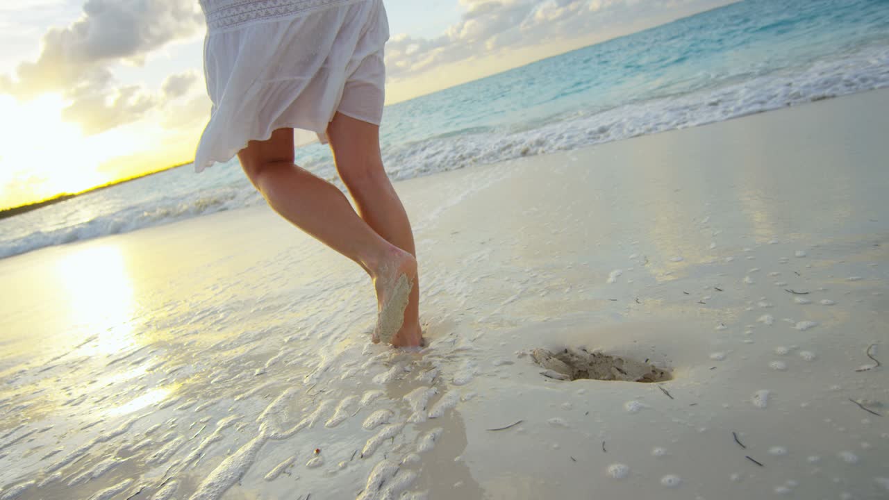 piernas caucásicas mujeres descalzas en la playa al atardecer