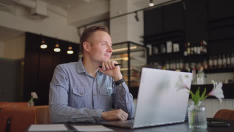 thoughtful serious young man student writer sit at home office desk with laptop thinking of inspiration search problem solution ideas lost in thoughts concept dreaming looking away