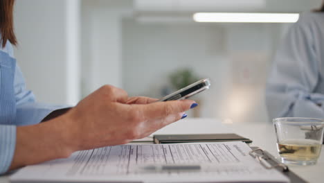 employee hands touching mobile phone screen closeup. businesswoman browsing web