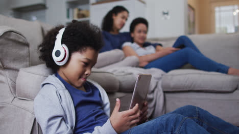 chica de raza mixta usando una tableta con auriculares