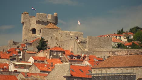 tourists walking along the wall in dubrovnik, croatia, heading up to the northwest tower