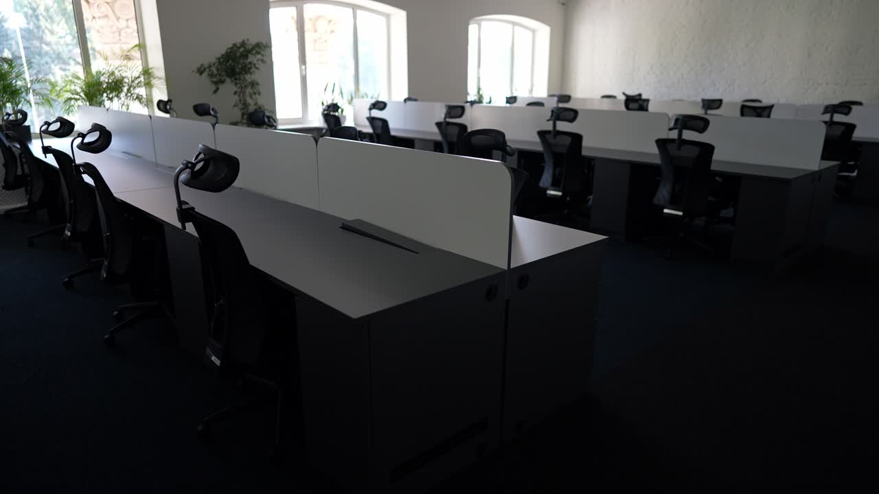Wide shot empty modern business office with no people inside. Long tables and chairs standing indoors with nobody on Covid-19 pandemic. Quarantine and lockdown concept.