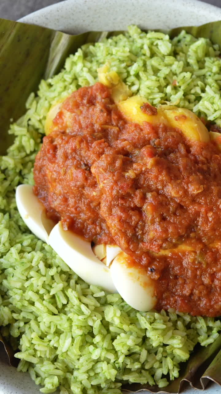 Vertical video showcasing a vibrant Colombian fiambre with leafy greens, eggs, and red sauce on a banana leaf. Perfect for mobile and social media. Rich textures and colors