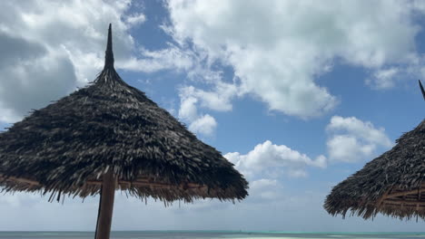 two straw umbrellas on a tropical beach