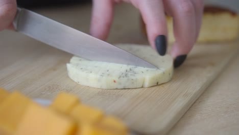 slicing luxurious mature cheese. close-up on a woman's hand preparing a tasty delicacy