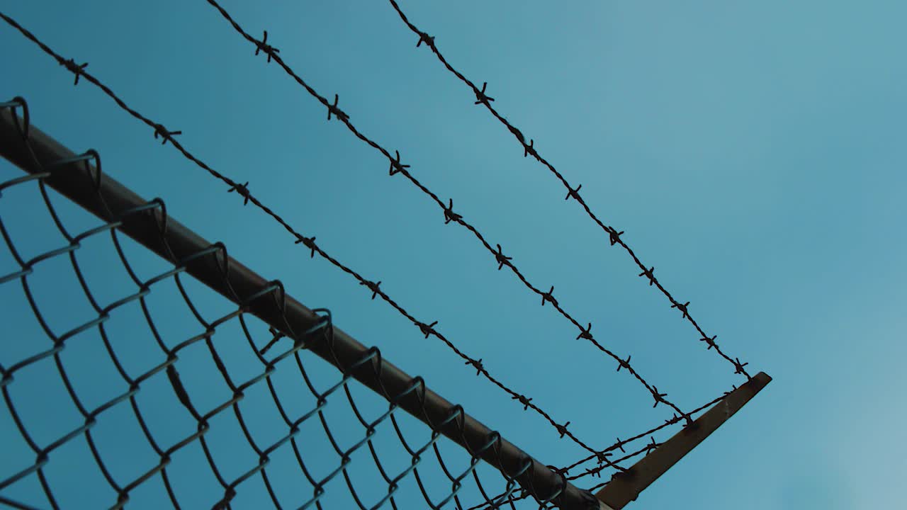 보호를 위해 금속 울타리에 철조망 - 틸트 업 샷