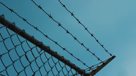 Barbed-wire-on-a-metal-fence-for-protection---Tilt-up-shot