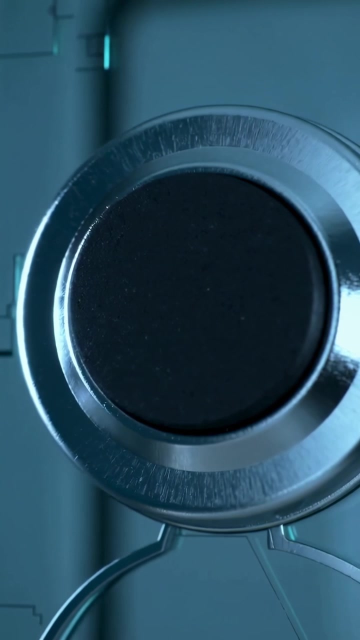 Vertical video: Dolly panning camera revealing circular device in lab to center, showing black pad