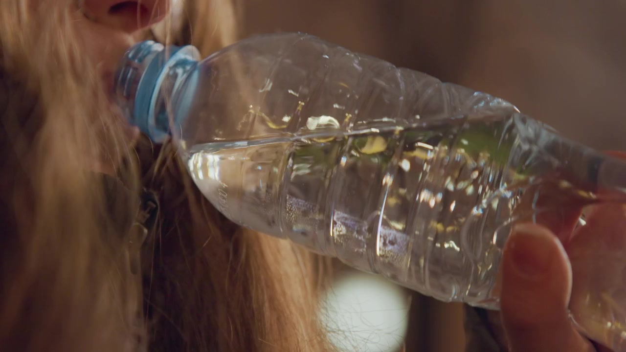 Femme boit de l'eau la nuit. Femme calme boit de l'eau avant de dormir. Scène nocturne d'une femme savourant une boisson rafraîchissante. Femme sereine avec des lunettes prend un moment pour boire de l'eau pendant la nuit