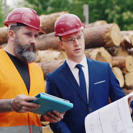 Two-engineers-study-the-drawings-with-scaffolding-in-the-background-2