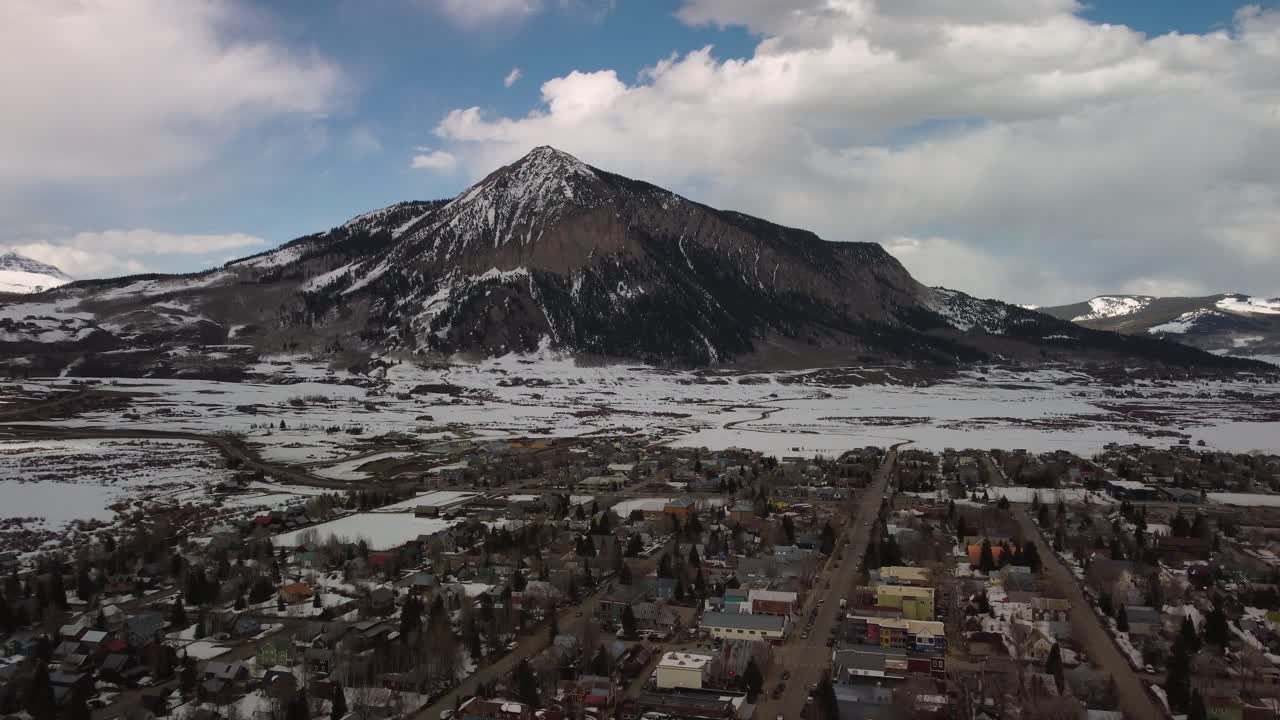 Camera tilts over a Colorado mountain town to reveal Mount Crested Butte, Aerial