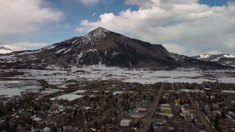 camera tilts over a colorado mountain town to reveal mount crested butte, aerial