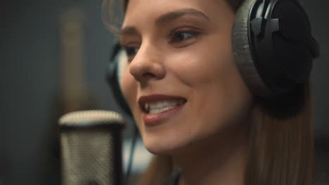 una hermosa vocalista canta una canción con micrófono en el estudio