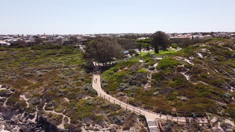 people walking on the boardwalk at the ocean reef, perth in australia