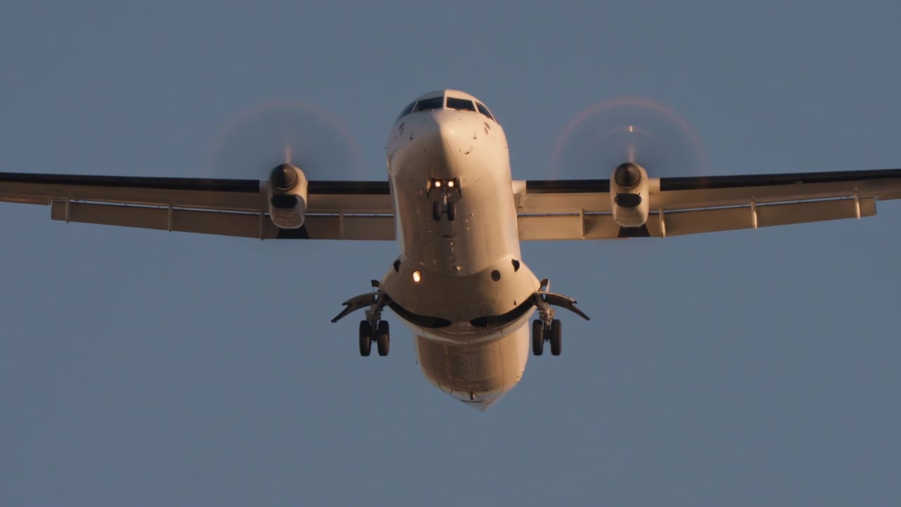 Pesawat Turboprop Putih Mendekat untuk Mendarat di Langit Cerah