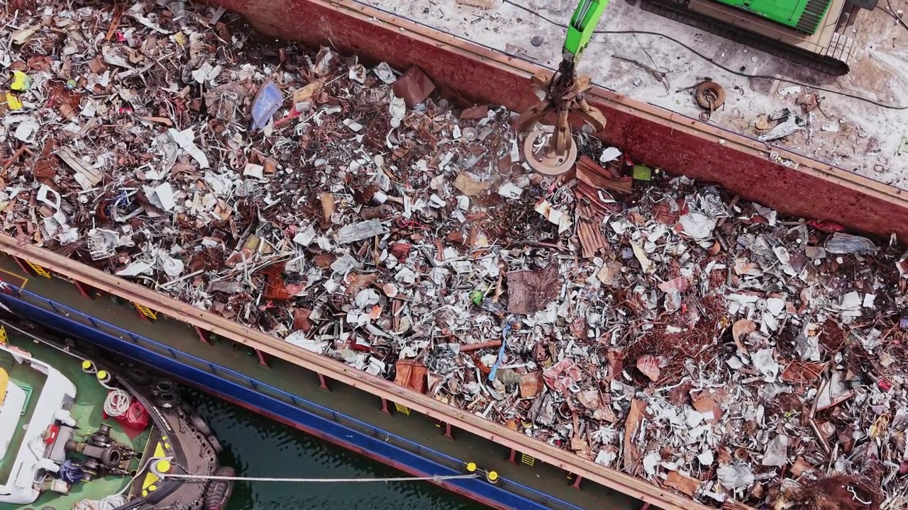 Operazione di smaltimento dei rifiuti si svolge su una chiatta in un porto cittadino