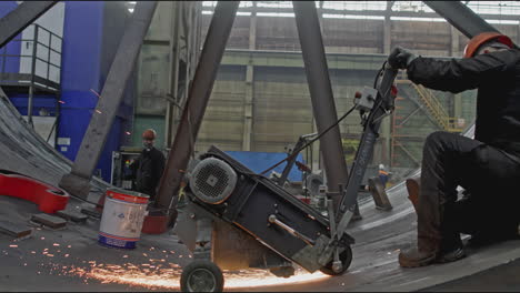 metal worker grinding steel in industrial setting