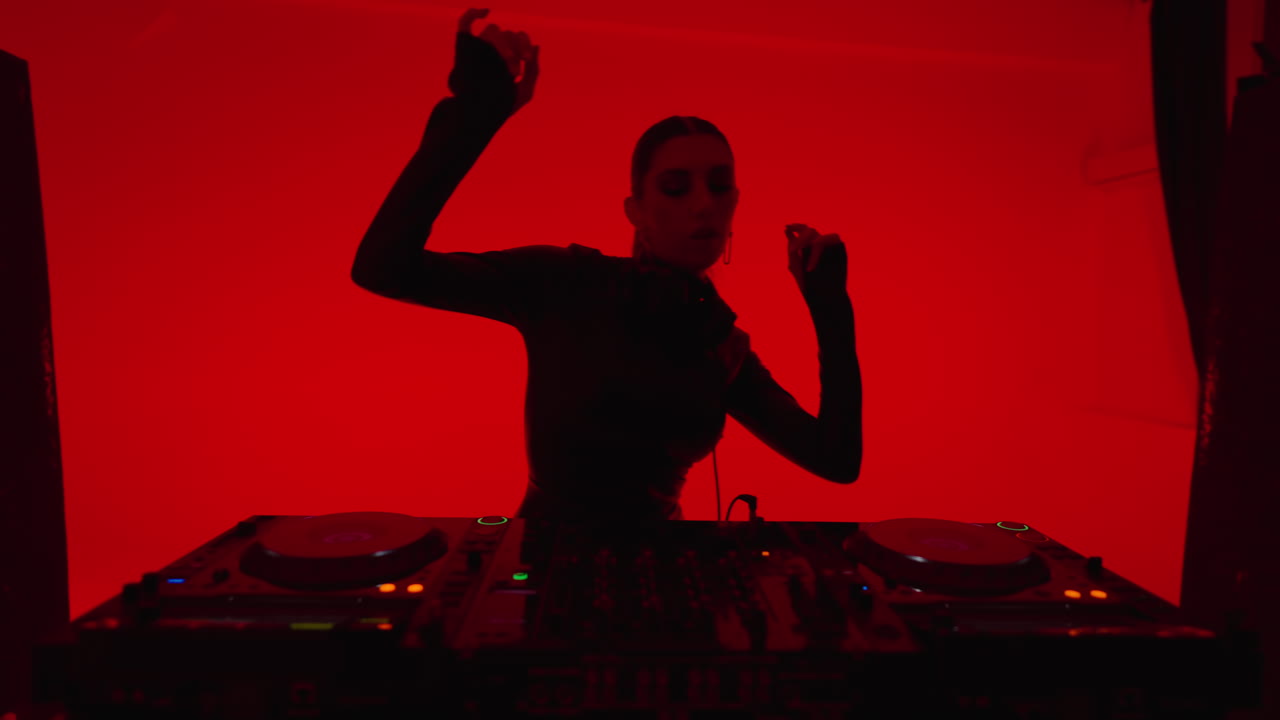 una mujer tocando en un estudio iluminado en rojo.