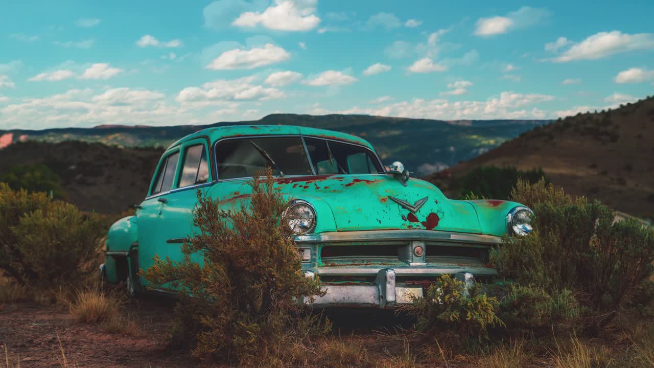 시네마그래프 - 덤불 옆에 있는 애리조나 사막에 서 있는 오래된 녹슨 민트 그린 빈티지 크라이슬러의 매끄러운 비디오 루프