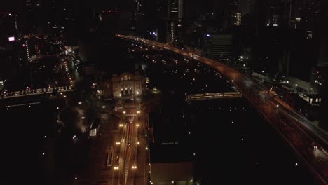 Dark-Moody-Scene-in-Osaka,-Aerial-Pullback-as-Cars-travel-past-Nakanoshima