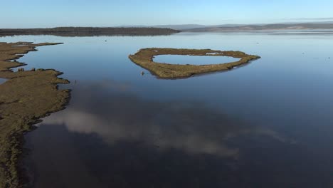 aerial approaching shot of water reflection of lake surface in tasmania