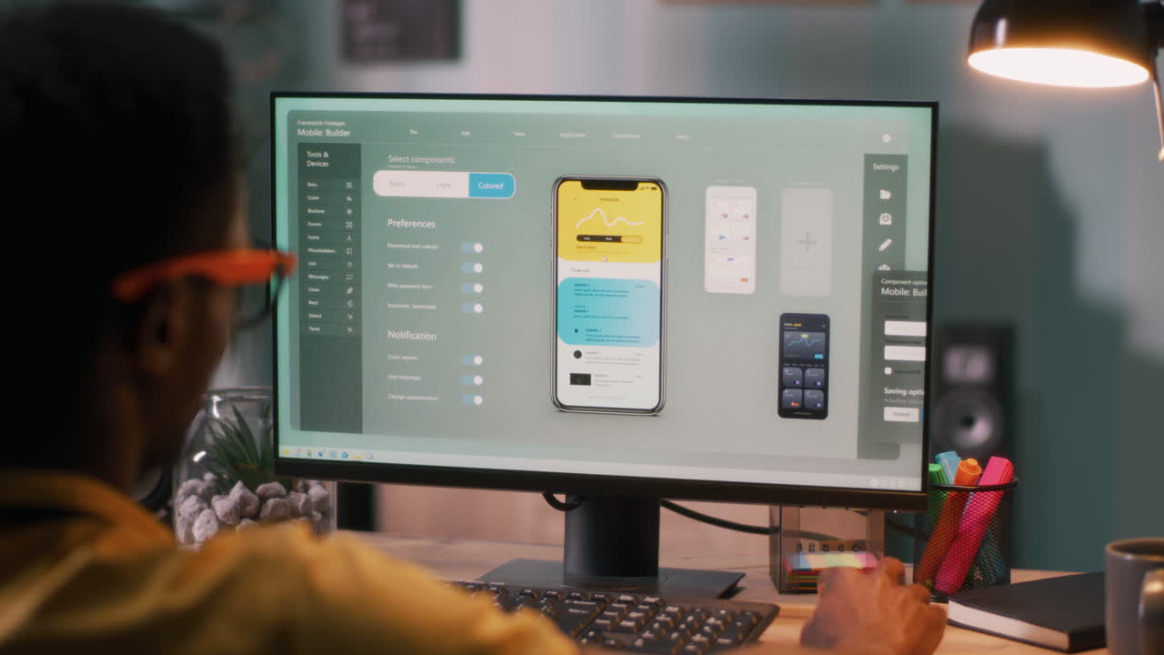 Person Designing Mobile App Interface on Computer