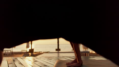 Two-guys-stretch-to-the-side-and-do-yoga-on-a-sunny-beach-in-the-morning.-Morning-exercises-and-zen