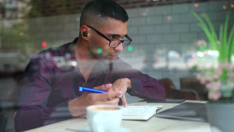 hispanic male entrepreneur reading notes in cafe