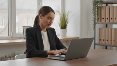 mujer de negocios trabajando en una computadora portátil en la oficina