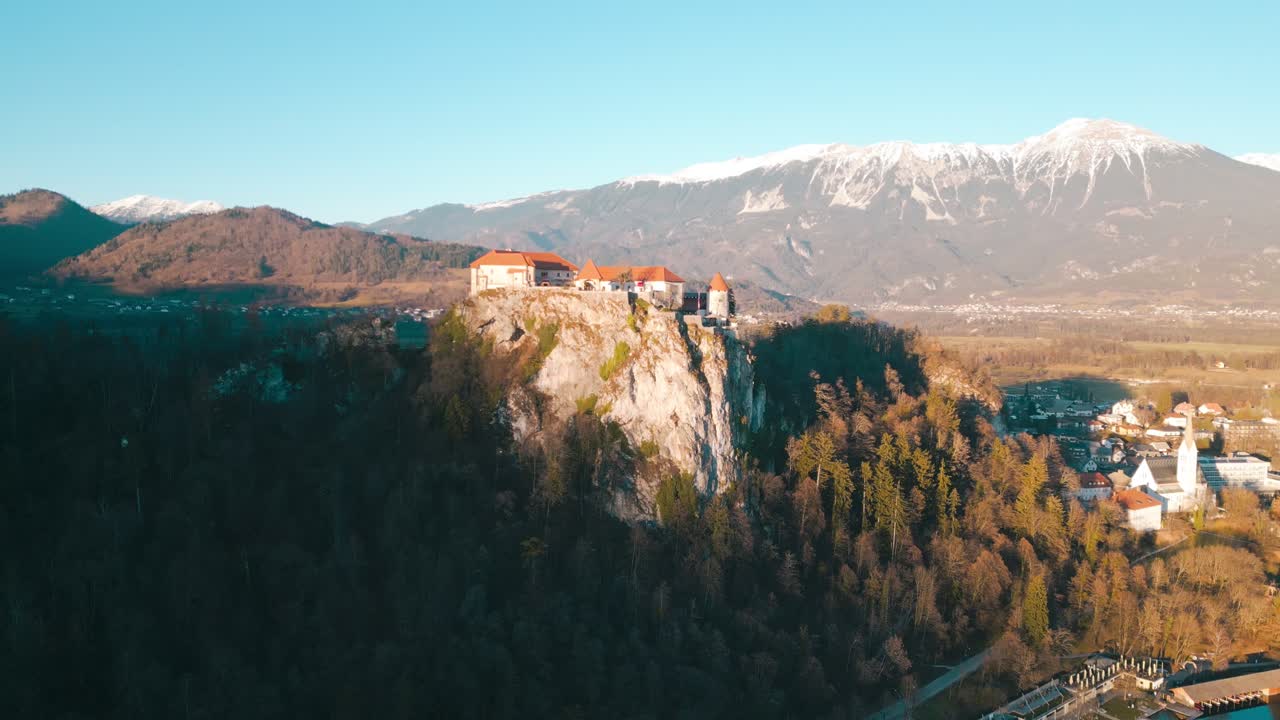 Il drone si muove parallelamente al lungomare, catturando il magnifico Castello di Bled con la sua posizione dominante sulla scogliera che si affaccia sull'iconico Lago di Bled.