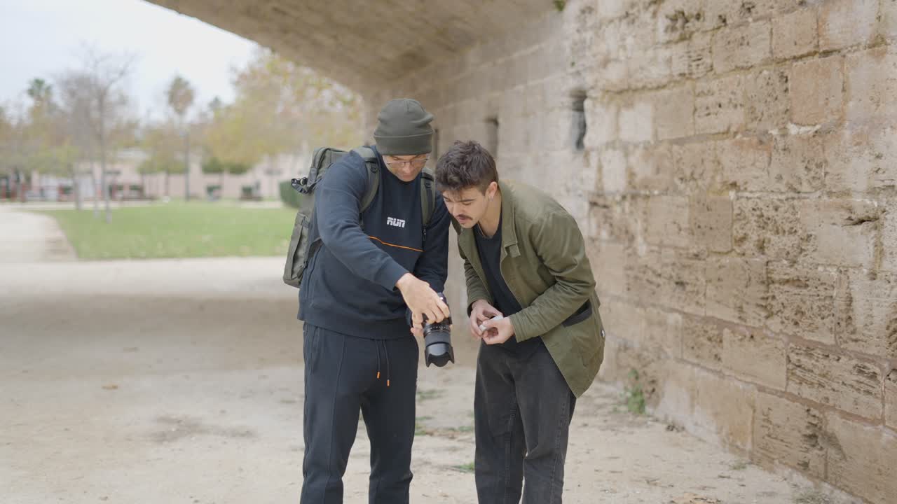 Two men learning photography outdoors