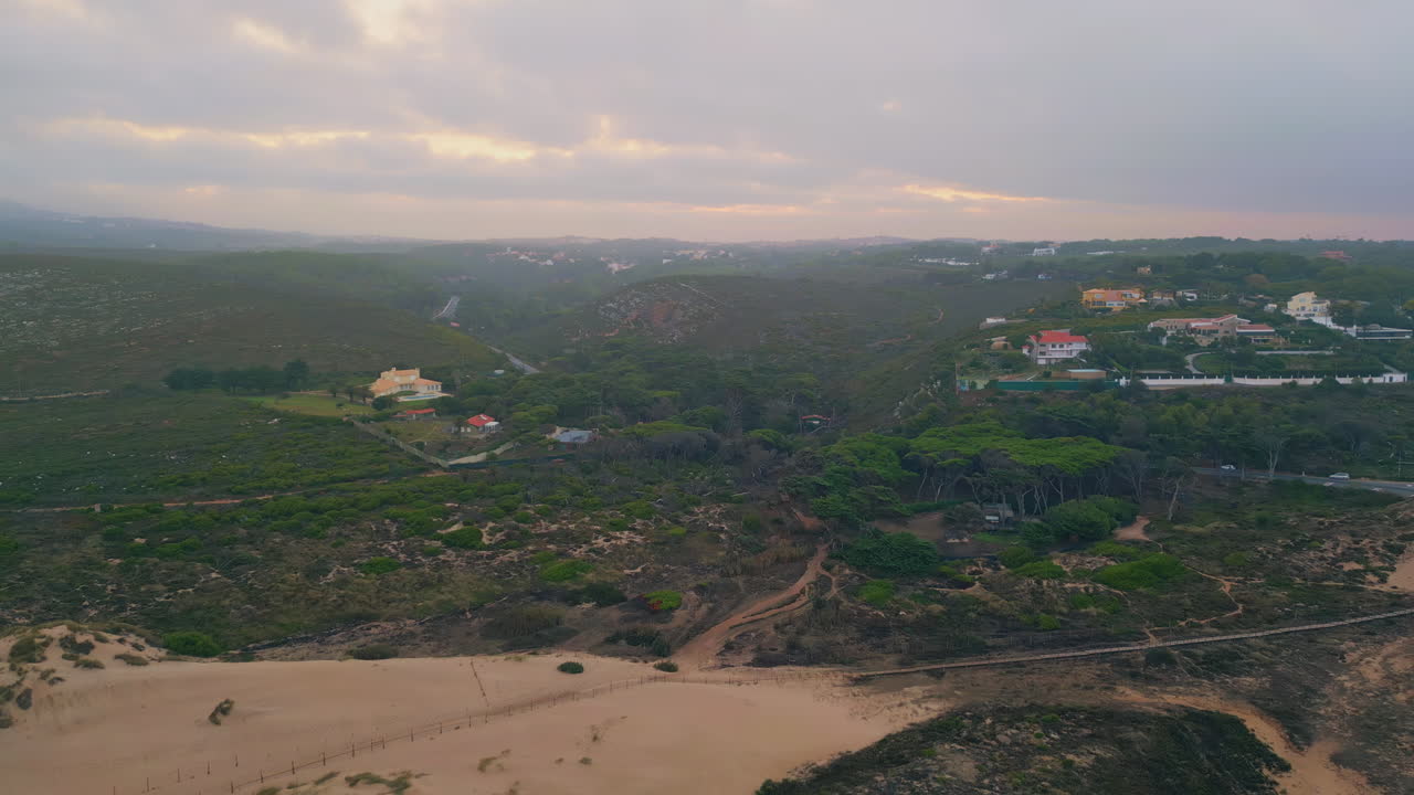 Cinematic cloudy nature valley under thunder sky. Drone view little village