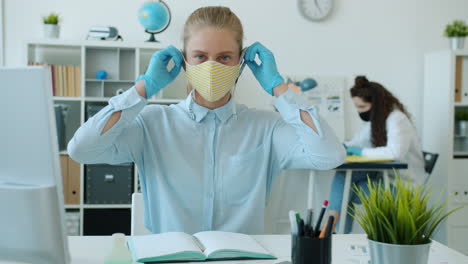 woman wearing mask and gloves in office setting