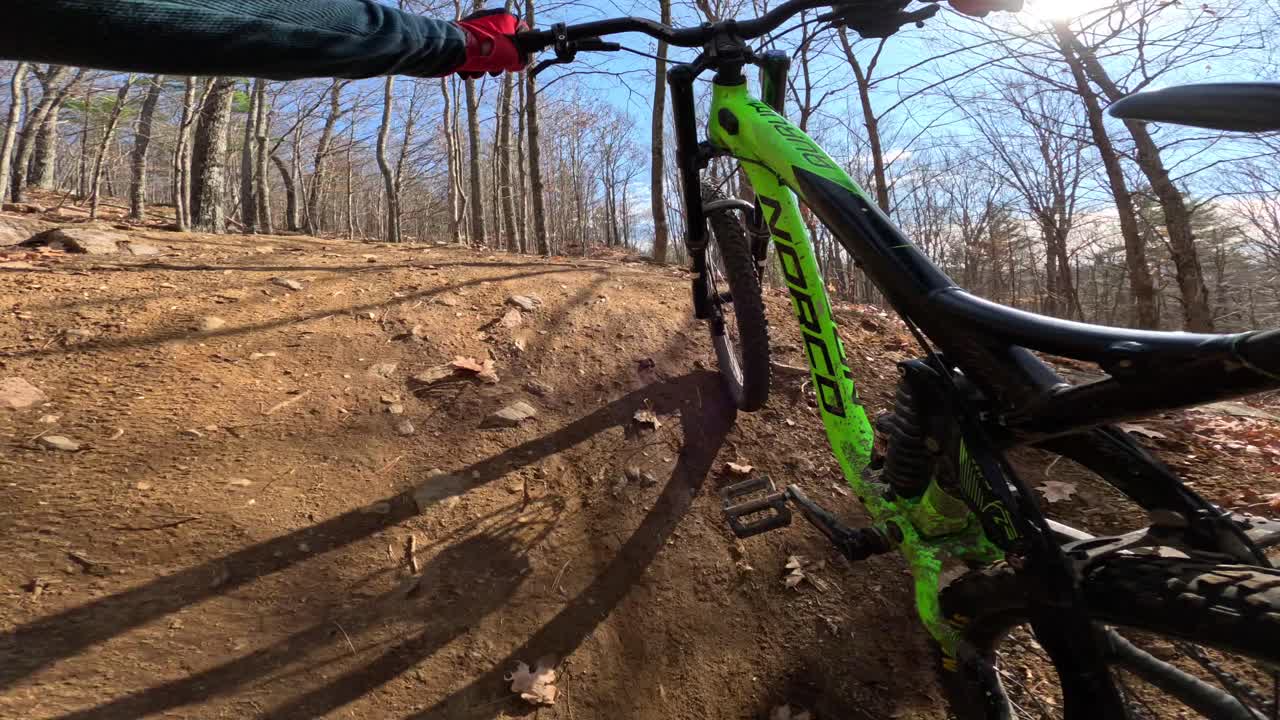 mtb rider pov empujando bicicleta por sendero forestal soleado en otoño