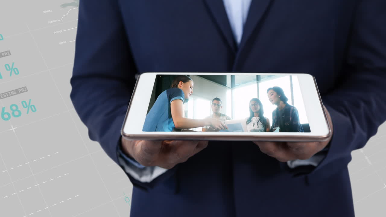Professionista con tablet in mano, con grafici di dati globali visualizzati sopra i colleghi in riunione