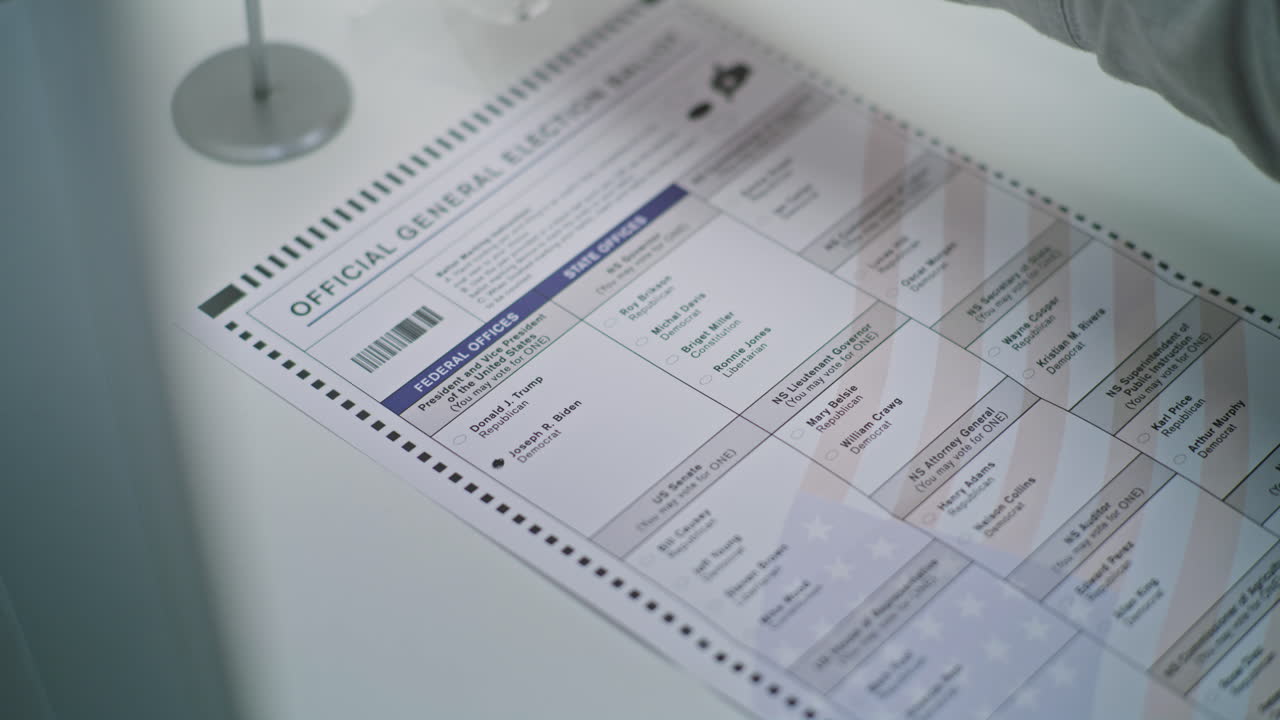 Anonymous American Male Citizen Votes for Joe Biden on Paper Bulletin Close up of Anonymous American Male Citizen Filling out Paper Bulletin in Voting Booth African American Man Votes for Joe Biden at Polling Station National Election Day in United States Civic Duty