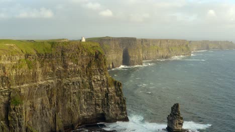 reverse aerial dolly revealing the sea stack at the cliffs of moher