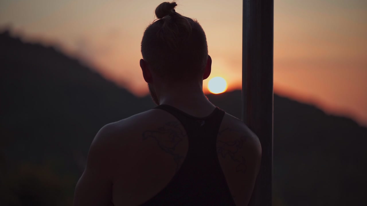 Man Watching Sunset Over Mountain Landscape